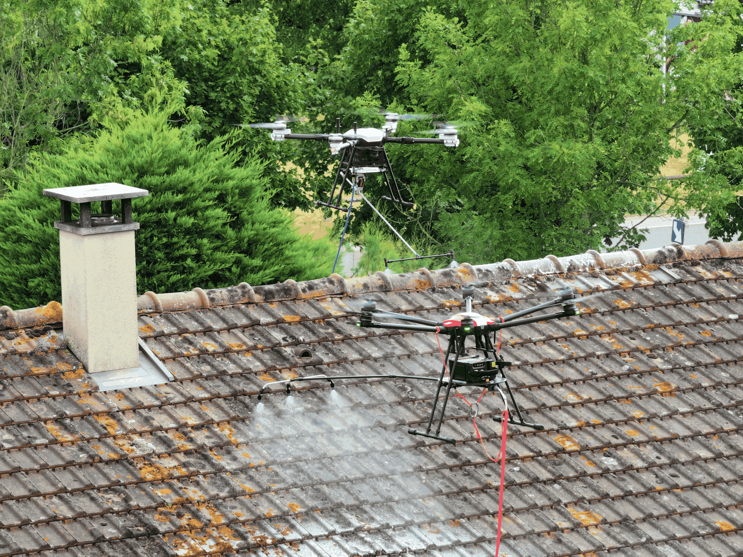 Deux drones professionnels intervenant pour le traitement d’une toiture en tuiles